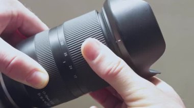 Eller, 17-70 mm 'lik ayarlanabilir odak uzaklığı ile 17-70 mm' lik merceği tutar..