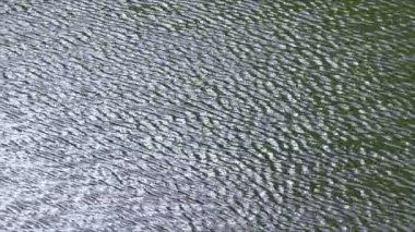 Dalgalanmalı su yüzeyinin dokusu yumuşak ve dinamik bir görsel etki yaratıyor..