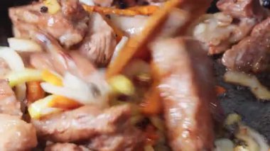 Cızırdayan kaburgalar tavada pişiyor.