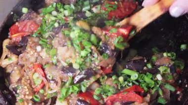 Kızarmış patlıcan, yeşil soğan ve tavada kırmızı biber..