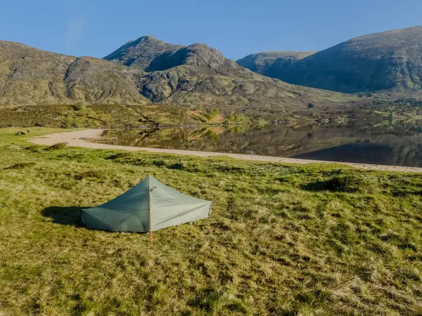 İskoçya 'nın batısındaki Affric Gölü' nün kıyısında çadır kurmak için güzel bir yer. Arka planda İskoç Dağları var. Gölün ya da gölün suyundaki yansımalar. Huzurlu sabah sahnesi.