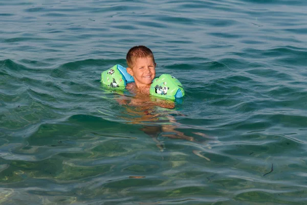 Happy Kid Korzystających Podczas Pływania Opaską Ramię Morzu — Zdjęcie stockowe