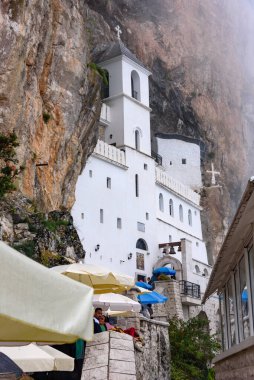 Karadağ, Ostrog - 6 Ağustos 2023. Dağlardaki Ostrog Manastırı, deniz seviyesinden yaklaşık 900 metre yükseklikte faaliyet gösteren bir Sırp Ortodoks manastırı. XVII yüzyılda kurulmuş.