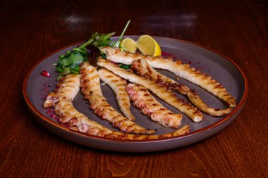 Tabağında limon olan ızgara ahtapot.