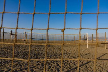 Kumsalda voleybol sahası. Plajda voleybol ağı var. 