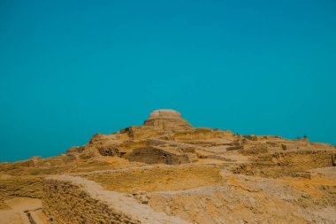 Mavi gökyüzünün arka planında antik Mohenjo Daro Indus Uygarlığının kalıntıları görülüyor.