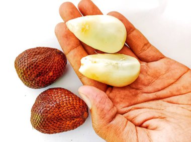 Birisi elinde salak meyvesi tutuyor.