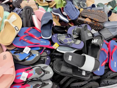 Dükkanda satılık sandalet yığını.