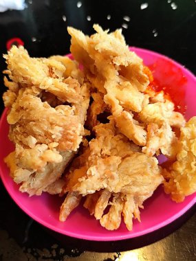 Plastik tabakta servis edilen kızarmış mantarlar.