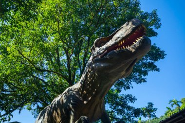 Dinozor eğlence parkında elektirikli dinozor sergisi, dinazor modeli görkemli ve canlı gibi.