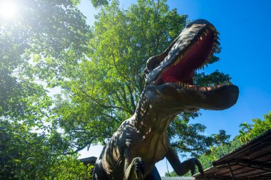 Dinozor eğlence parkında elektirikli dinozor sergisi, dinazor modeli görkemli ve canlı gibi.