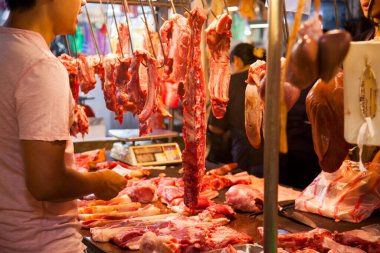Farklı domuz kesimleriyle dolu domuz eti satıcısı rafları.