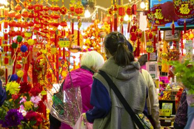 Çin Yeni Yıl Malları Caddesi 'ndeki insanlar Bahar Festivali için süslemeleri seçiyorlar (Yazı: hayırlı, bahar, zenginlik ve hazine çeken)
