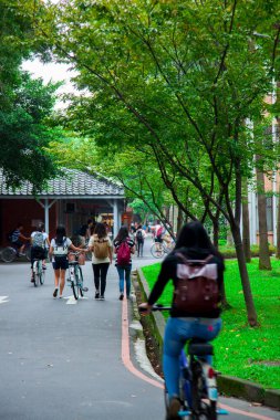 There are many college students who have just finished class on the sidewalk on campus