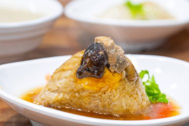 Masanın üzerinde manyetiksel bir kasede buharda pişmiş et var.