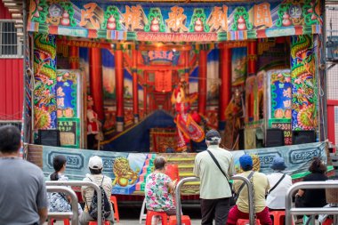 Tapınağın önünde, birçok insan Tayvan 'da geleneksel bir halk operası olan Gezixi' nin performansını izliyor..