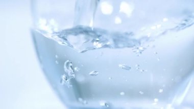 Yüksek hızlı çekim. Temiz maden suyu bardağa doluyor.