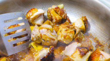 Kızarmış tavuk parçalarını yakın çekimde karıştır.