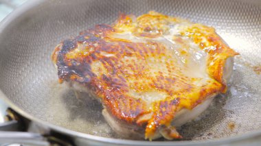 Tencerede kızarmış tavuk bacağı var.