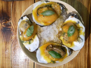 oysters with cheese and garlic on a brown table