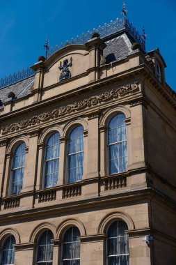 EDINBURGH - 28 Temmuz 2024: Edinburgh 'daki Ulusal Müze' nin yanındaki eski binanın ayırt edici cephesi açık mavi gökyüzüne karşı tarihi mimarisini sergiliyor.