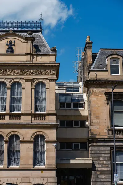 stock image EDINBURGH - JULY 28, 2024: Contrast of historic and modern buildings in Edinburgh showcases architectural diversity under a clear blue sky.