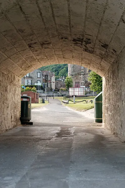 BURNTISLAND, FIFE, SCOTLAND, İngiltere - 11 Haziran 2024: İlginç bir köy yolu büyüleyici taş binaları ve yemyeşil alanları gözler önüne seriyor, sıcak bir yaz günündeki keşifleri davet ediyor.