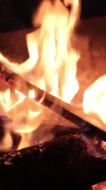 POKHARA, NEPAL - 7 HAZİRAN 2025: Pokhara, Nepal 'de bir akşam şenlik ateşinin sıcaklığı, sakin bir ortam ve parlak bir renkle çevrili, el kamerasıyla yakın çekim, dikey.