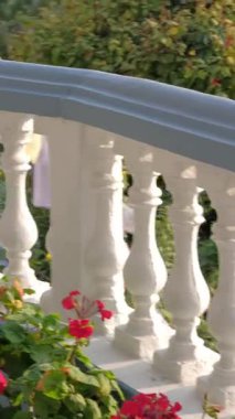 POKHARA, NEPAL - 16 HAZİRAN 2025: Canlı çiçeklerle süslenmiş güzel bir balkon ve sakin bir ortamda geçen zarif bir korkuluk, dikey