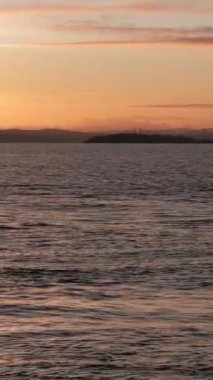 BURNTISLAND, FIFE, SCOTLAND, İngiltere - 4 Ocak 2025: Gökyüzünün sakin denizle buluştuğu ve Burntisland West Pier Lighthouse 'un ufka karşı dik durduğu,.