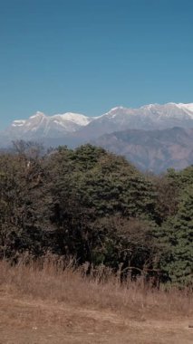GHOREPANI, NEPAL - 10 HAZİRAN 2025: Ghorepani 'deki Himalayaların manzaraları, yüksek zirveler ve yemyeşil alanlar çarpıcı bir manzara, pan.