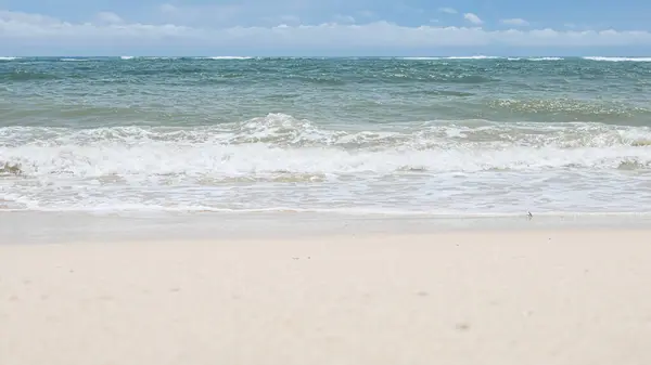 BALI, İNDONEZYA - 22 HAZİRAN 2018: Güneşli bir günde Pandava Sahili 'nin temiz kumu ve Hint Okyanusu dalgaları eziliyor, Bali.