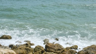 BALI, INDONESIA - JANUARY 22, 2018: Rocks and Indian Ocean powerful crushing waves near Pandawa Beach, Bali.Sunny day clipart