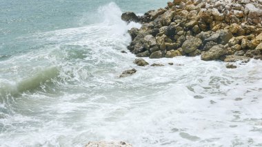 BALI, INDONESIA - JANUARY 22, 2018: Ocean Ocean waves hit rocks near Pandawa Beach, Bali. clipart