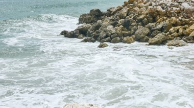 BALI, INDONESIA - JANUARY 22, 2018: Calming ocean waves hit rocks near Pandawa Beach, Bali. clipart