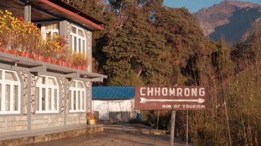 Tadapani 'de sarı çiçekli bir misafir evi. Chhomrong köyüne giden yolun başındaki işaret. Doğal güzellik ve sakin atmosfer..