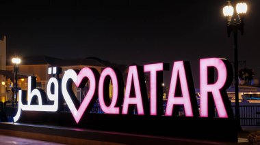 DOHA, QATAR - 6 Ocak 2025: I Love Katar 'ı Seviyorum tabelasını gösteren, gece boyunca Doha' nın canlı ruhunu gösteren, pembe neon ışıklarıyla parlayan parlak tabela