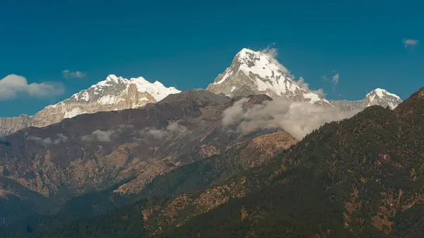 GHOREPANI, NEPAL - 9 HAZİRAN 2025 Annapurna sıradağlarının güzelliği, Ghorepani 'den manzara, sıcak altın saat ışığı çarpıcı manzaranın üzerine serin bir parıltı saçar.