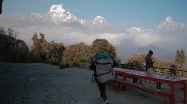 TADAPANI, NEPAL - 10 HAZİRAN 2025: Porter Tadapani, Nepal 'de onu takip eden devasa ağır çanta ve yürüyüşçüler, çarpıcı dağlar ve çevrelerindeki sakin atmosfer.