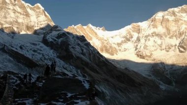 ANNAPURNA Üs Kampı, NEPAL - 14 HAZİRAN 2025: Annapurna 'nın sakin sabahında Annapurna Dağları' nı aydınlatan nefes kesici gündoğumu zirveleri, doğanın güzelliğini yansıtıyor, pan.