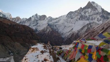 ANNAPURNA Üs Kampı, NEPAL - 14 HAZİRAN 2025: Annapurna Saha Kampı 'ndan nefes kesici sabah manzarası yüksek zirveler ve renkli bayraklarla çevrili, geniş açı, kış manzarası.
