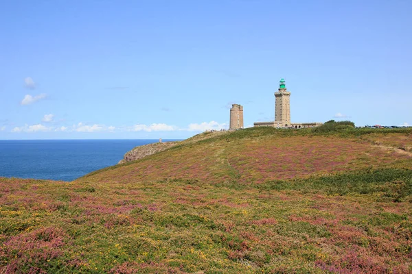 Old lighthouse and meadow full of flowers at Cap Frehel, Brittany.