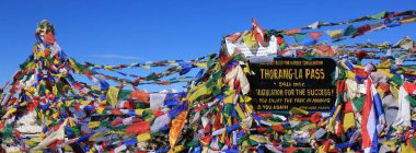 Thorang La dağ geçidinde dua bayrağı ve tabela, Nepal.