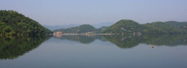 Begnas Gölü 'ne yansıyan yeşil tepeler, Nepal.