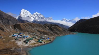 Gökyo 'daki pansiyonlar, Dudh Pokhari Gölü ve Nepal' deki Cholatse Dağı karla kaplı..