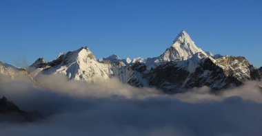 Mount Ama Dablam and other mountains reaching out of a sea of fog, Nepal. clipart
