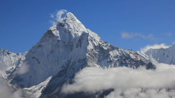 Snow capped peak of Mount Ama Dablam surrounded by clouds, Nepal.