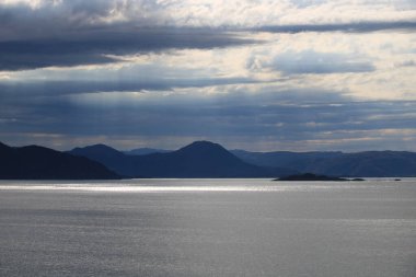 Kuzey Denizi 'nde gümüş şeritler, Bergen, Norveç yakınlarında dağ sıraları ve kasvetli gökyüzü.