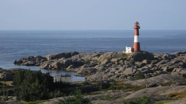 Cast iron Eigeroy lighthouse, rock formations and North Sea, Norway. clipart