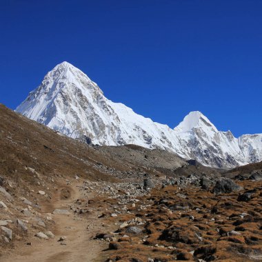 Everest Ana Kampı 'na doğru giden yaya yolu ve sonbaharda Pumori Dağı' nı kaplayan kar, 7138 metre, Nepal.